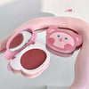 Pink makeup compact with cartoon character design on a light gray background
