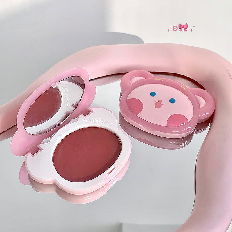 Pink makeup compact with cartoon character design on a light gray background
