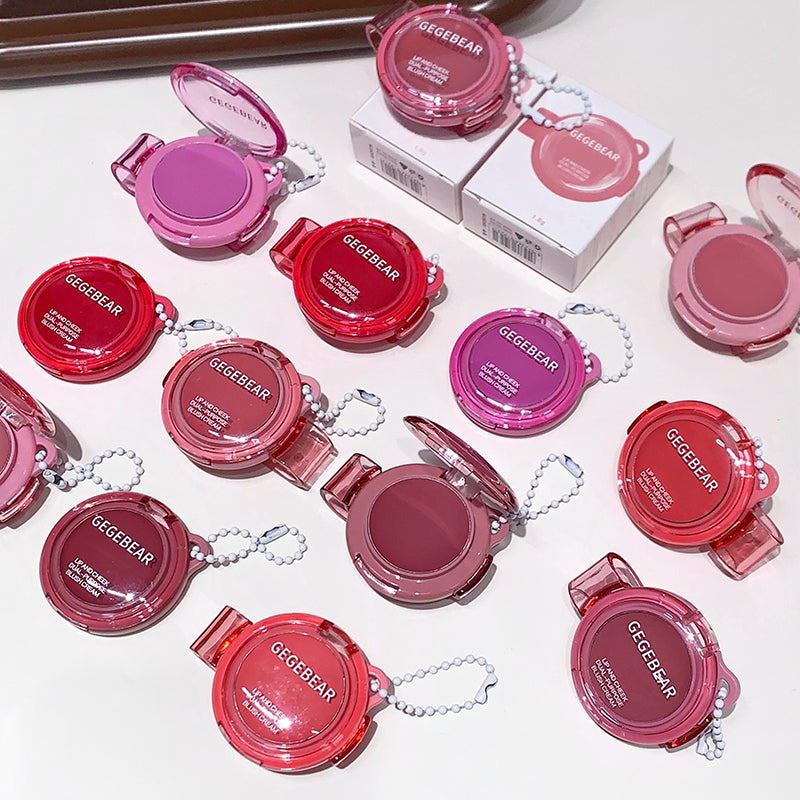 Multiple small makeup products with pink and red cases on a light background