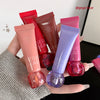 Hand holding four lip gloss tubes with 'GEGE BEAR' branding against a neutral background.