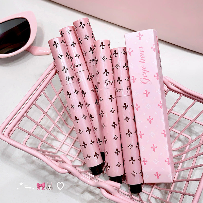 Pink and black patterned items on a pink wire basket with a cup of coffee in the background.
