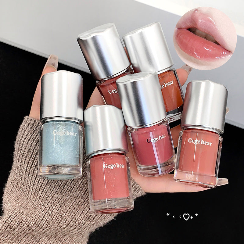 Set of Gegebear nail polishes held by a hand with a close-up of a lip wearing a similar shade.