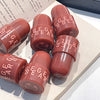 Red lipstick with 'Eige Bear' branding on a textured surface