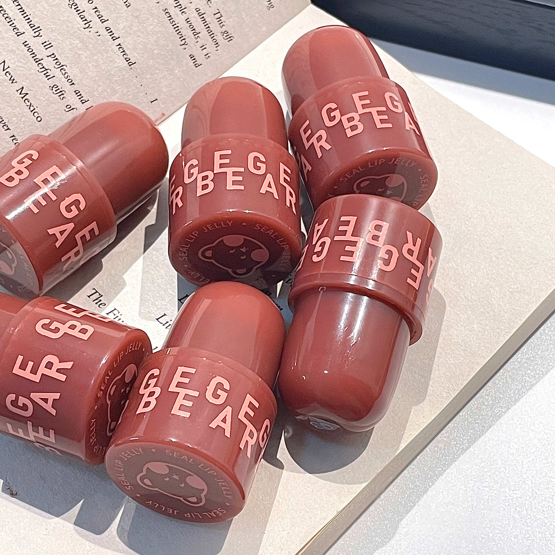 Red lipstick with 'Eige Bear' branding on a textured surface