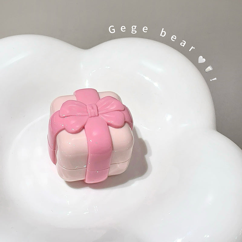 Pink and white bear-shaped container with a bow on a white background, featuring the brand 'Gege bear'.