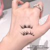 False eyelashes being held between fingers with a blurred background
