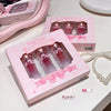 Pink Gege bear cosmetic set with lip glosses on a white surface.