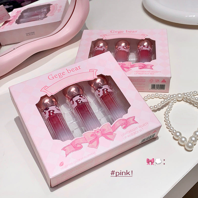 Pink Gege bear cosmetic set with lip glosses on a white surface.