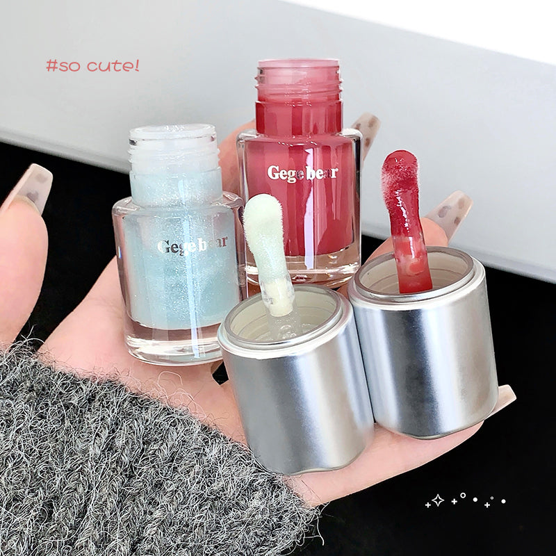 Hand holding three small containers with colorful liquids and 'Geggeber' branding.