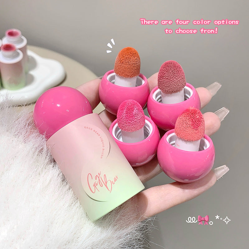Pink lip balm with sponge applicators on a hand, with text indicating color options.