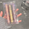 Four lipsticks in a clear packaging held by a person with a blurred background