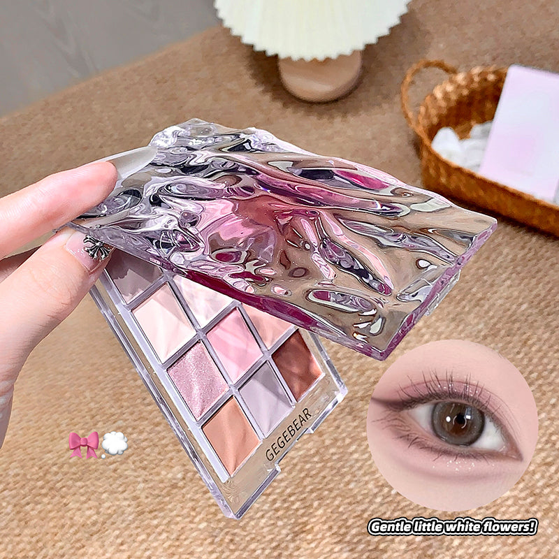 Makeup palette with pink and purple design held by a hand, close-up of an eye, and text 'Gentle little white flowers' on a beige background.