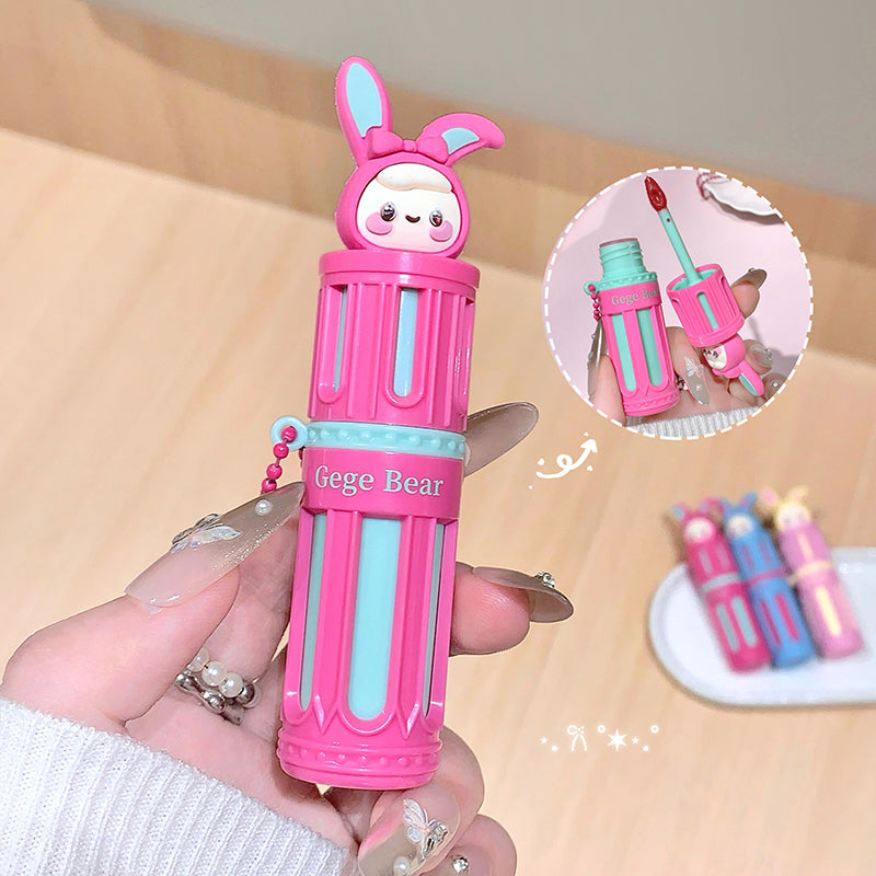 Pink and blue pen-shaped container with a bear design held by a hand on a beige background.