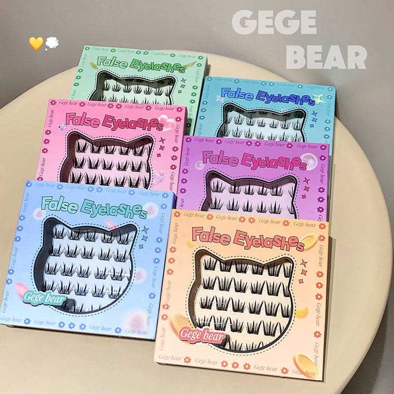 Five boxes of false eyelashes with colorful packaging on a beige surface, featuring the brand 'GEGE BEAR'.