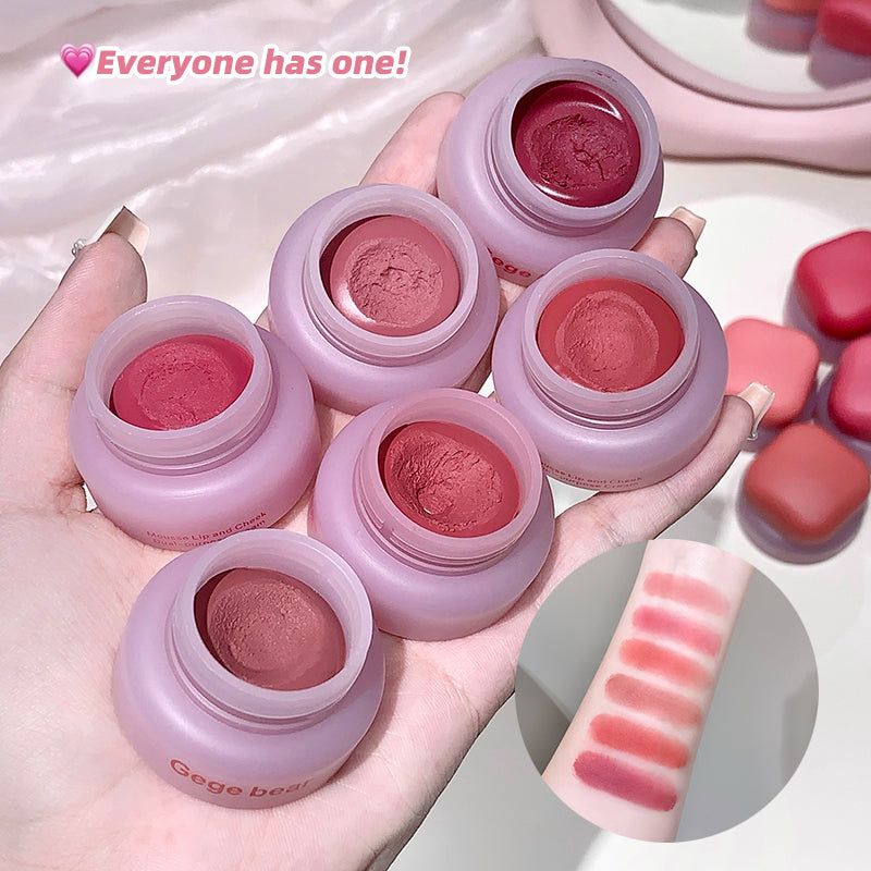 Pink lip balm jars with visible color swatches on a hand