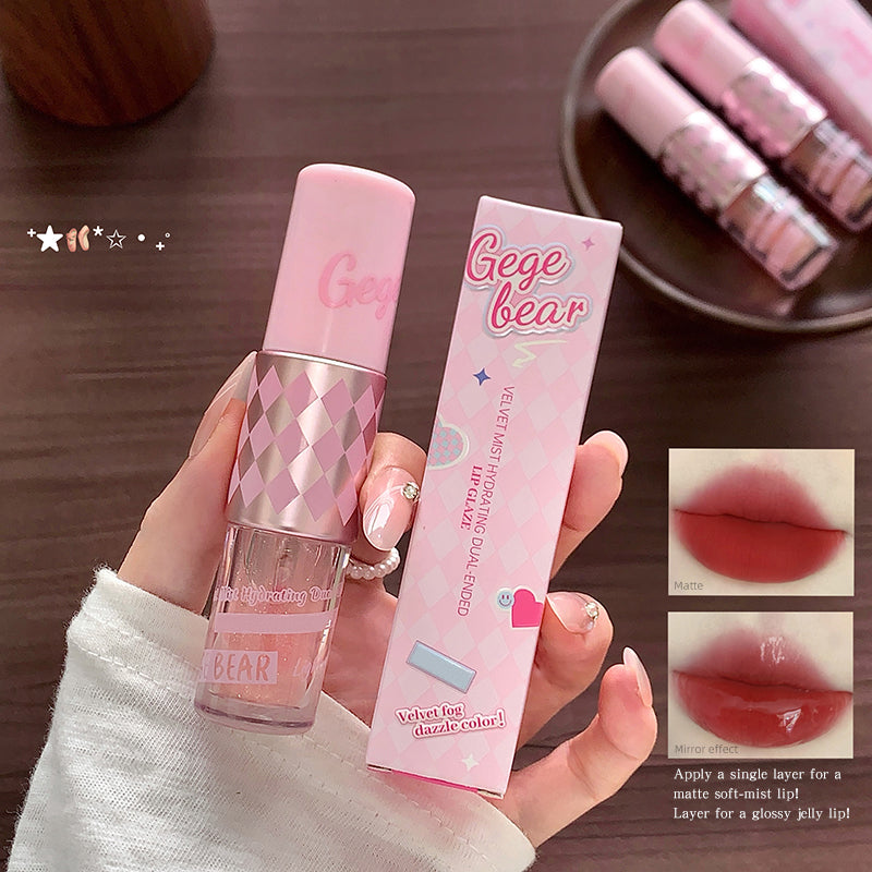 Pink lip gloss with packaging held by a hand on a wooden surface, with additional lip glosses in the background.