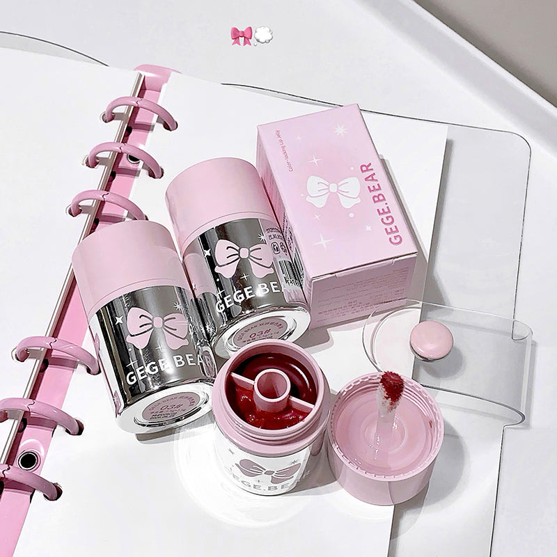 Pink and silver GEGER BEAR products including a water bottle, lip balm, and stationery items on a white surface.