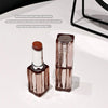 Two lip products on a white surface with text about moisturizing and clear lip makeup.
