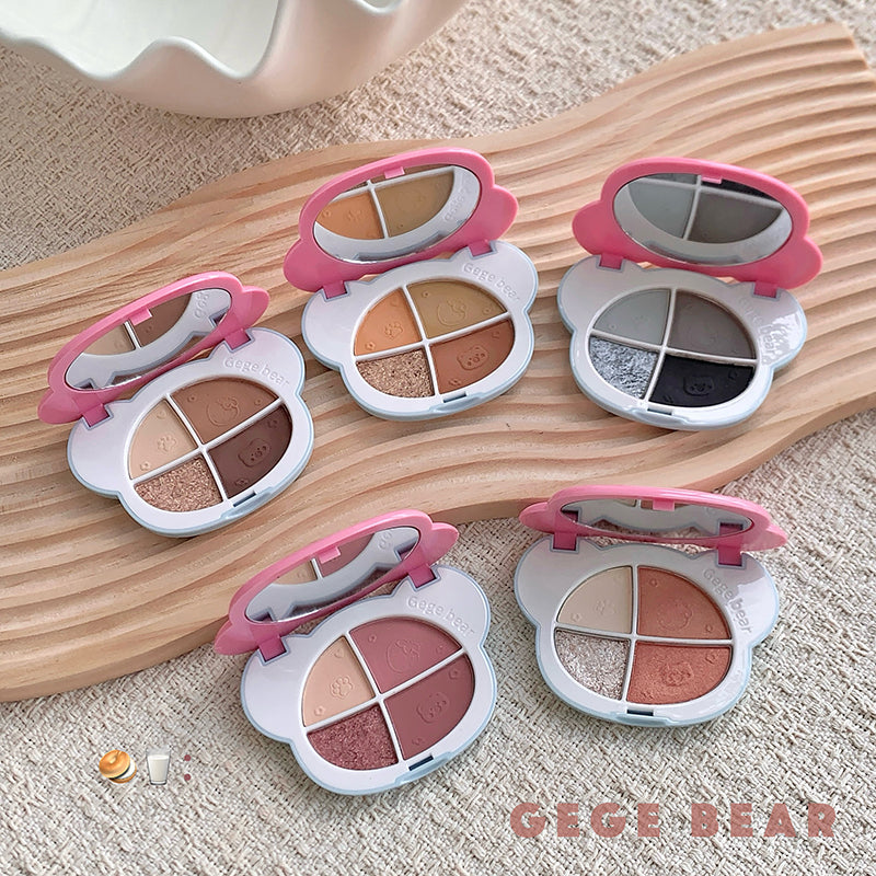 Five small makeup palettes with pink lids on a wooden surface, featuring the brand 'GEGE BEAR'.
