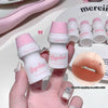 Small white bottles with pink caps labeled 'Geege bear' held by a hand.