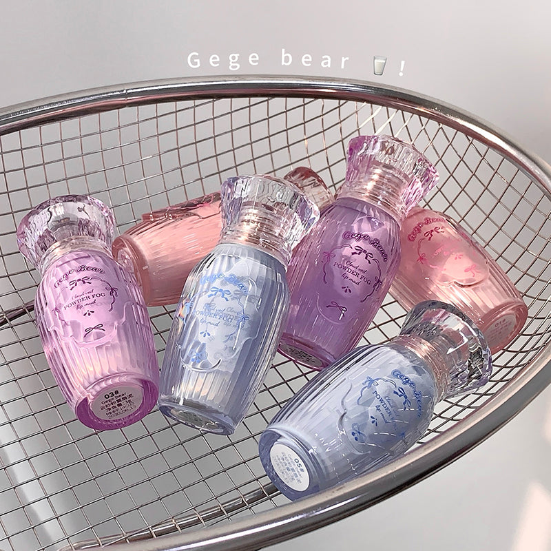 Set of pastel-colored glass bottles with decorative labels on a metal wire rack.