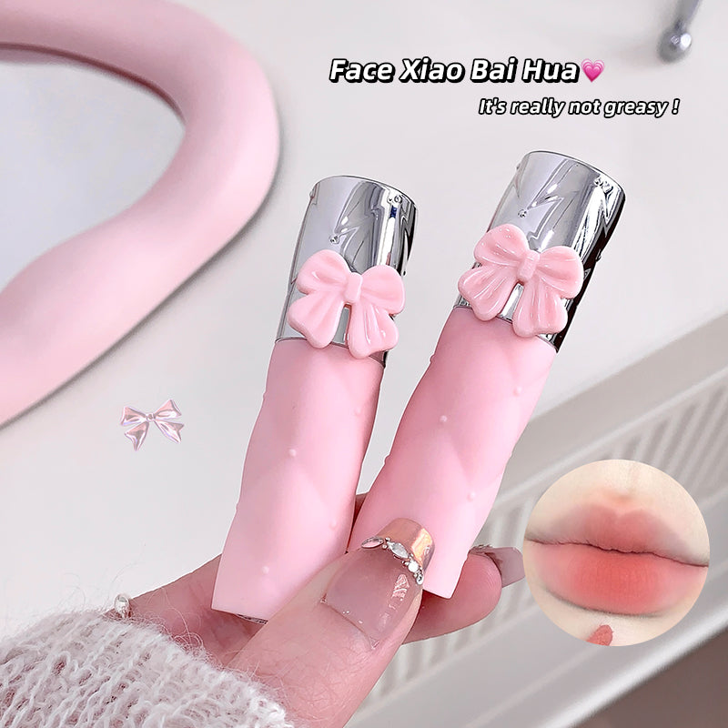 Pink lip gloss with a bow held by a hand, with a close-up of lips and text overlay.