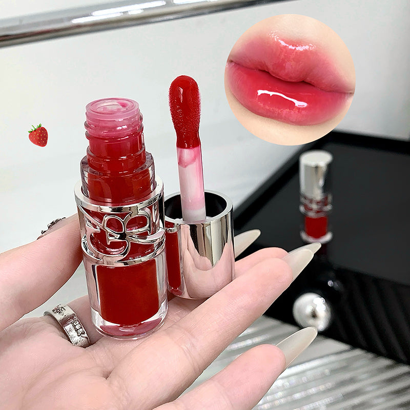 Red lipstick with silver cap held by a hand, close-up of lips with lipstick applied.