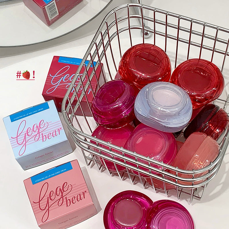Basket with pink and red containers and 'Gege Bear' boxes on a white surface