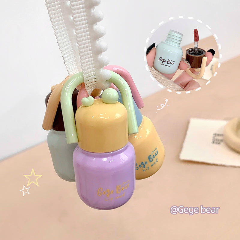 Set of pastel-colored bottles with handles on a light surface, featuring the brand 'Gege bear'.