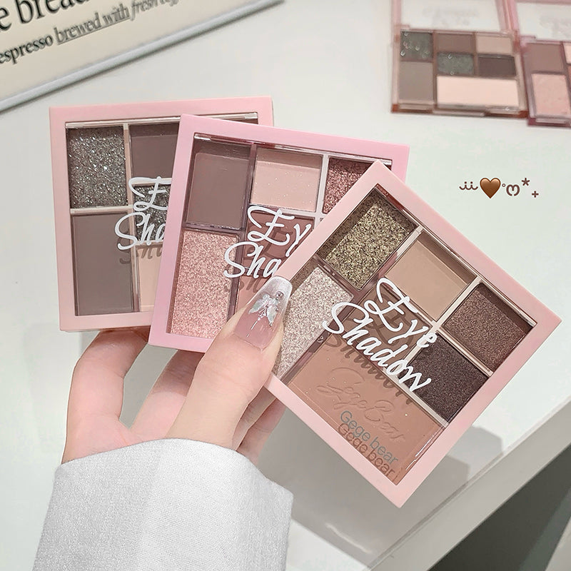 Makeup eyeshadow palettes with 'Eyes Shadow' text held by a hand on a light background.
