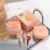 Pink cosmetic set with 'Gege bear' branding on a reflective surface.