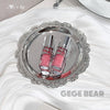 Two pink lip glosses on a silver tray with 'GEGE BEAR' branding.