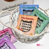 Basket with colorful boxes of false eyelashes on a white surface