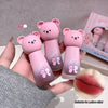 Three pink bear-shaped lip balms held by a hand, with a close-up of a lip and text 'Suitable for yellow skin' on a light gray background.