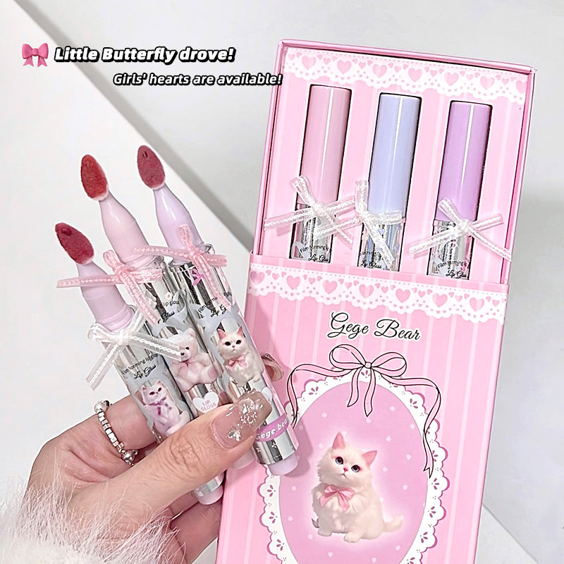 Set of pink and white pens with a decorative box featuring a cat illustration, held by a hand.