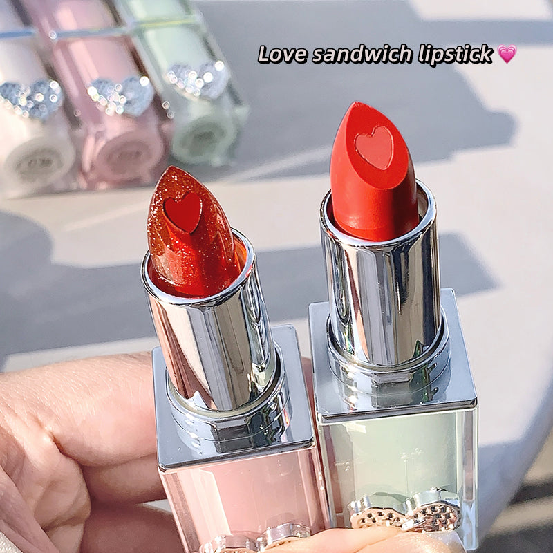 Two red lipstick with heart-shaped caps on a blurred background