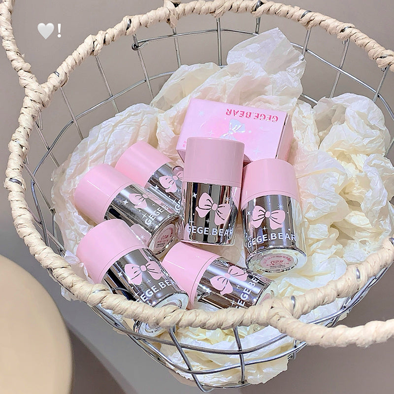 Basket with pink and silver bottles labeled 'GIGE BEAR' on a white lace fabric background.