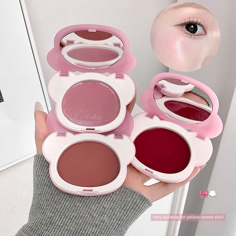 Set of pink makeup compacts with mirrors held by a hand, showing different shades.