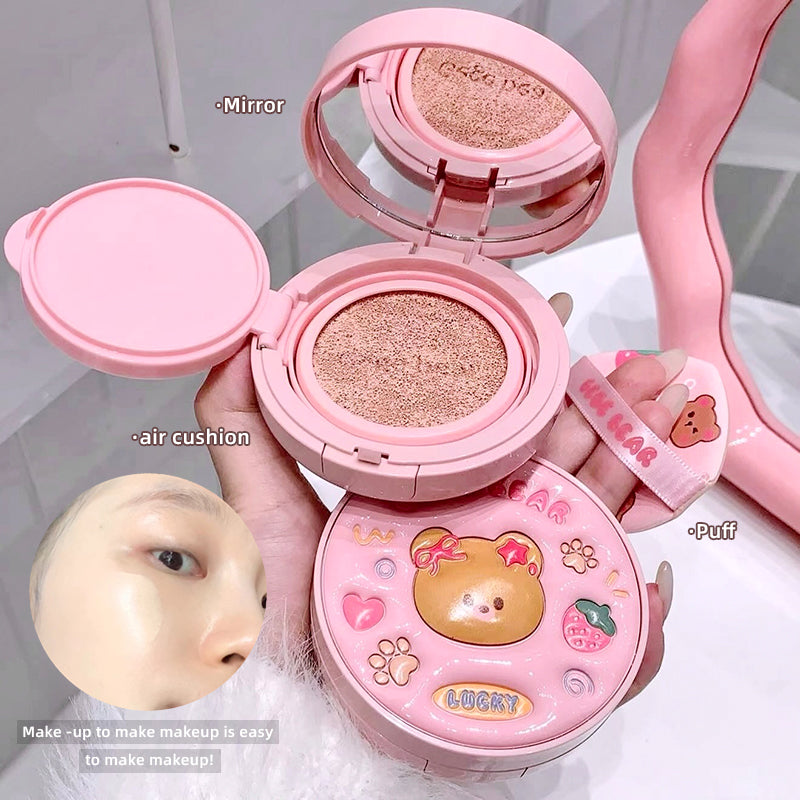 Pink cosmetic compact with mirror, air cushion, and puff, featuring a bear design.