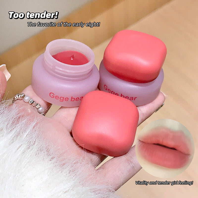 Pink lip balm with 'Gege bear' branding held by a hand, with text and inset of lips.