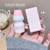 Small white bottle with pink cap and packaging held in a hand, branded 'GEGE BEAR'.