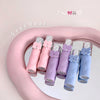 Set of colorful lip balms with decorative bows on a heart-shaped pink stand, branded 'Gege Bear'.