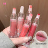 Hand holding four lip glosses with visible brand name, close-up of lips with gloss applied.