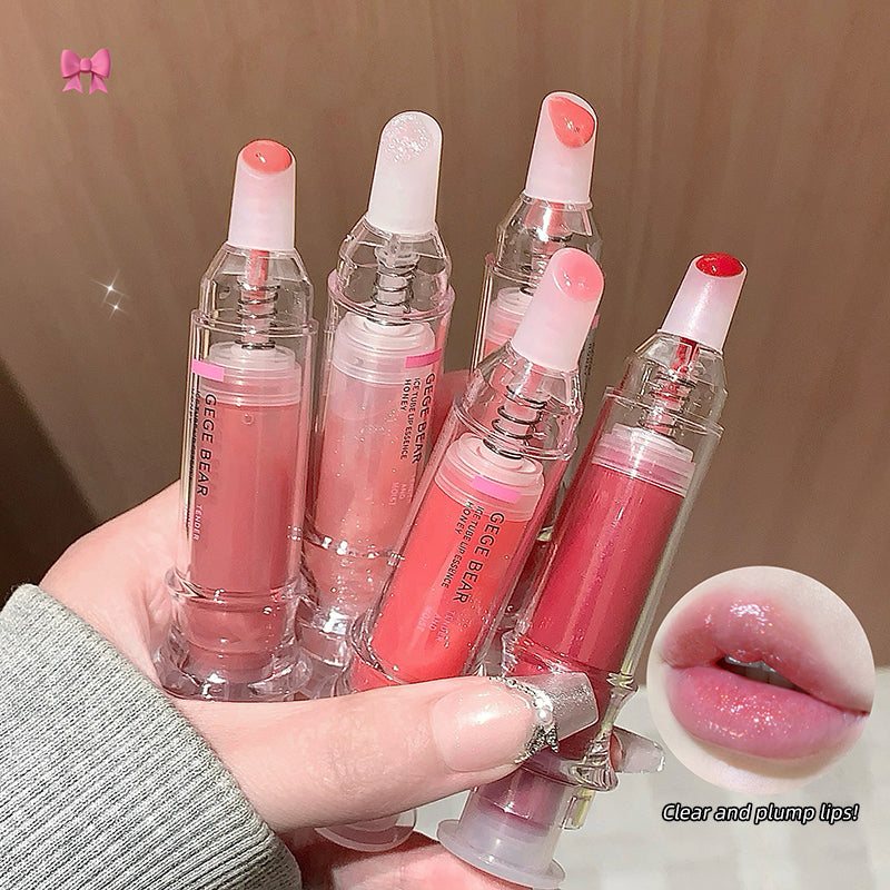 Hand holding four lip glosses with visible brand name, close-up of lips with gloss applied.