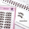 False eyelashes on a pink display card with a planner in the background