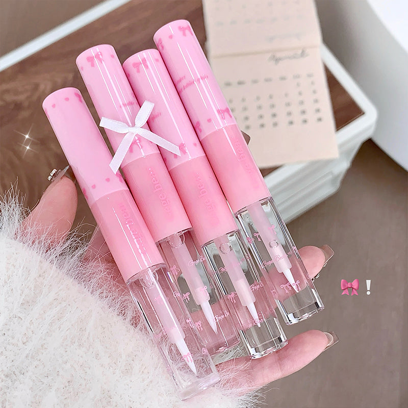 Set of pink lip glosses held in a hand with a blurred background