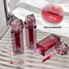 Red lip gloss with applicator and packaging on a textured surface
