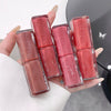 Hand holding six lip glosses with 'BE BEAR' branding.