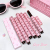 Set of pink lip products with black patterns on a white surface, featuring the brand 'Gege Bear'.
