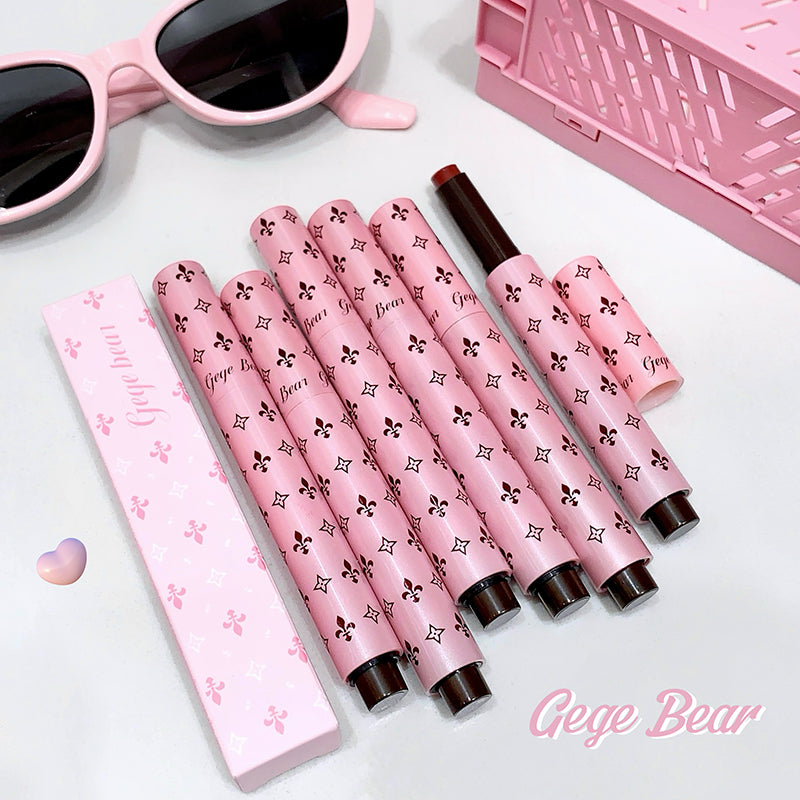 Set of pink lip products with black patterns on a white surface, featuring the brand 'Gege Bear'.